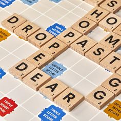 scrabble tiles spelling the word droppaste on top of each other with words written across them