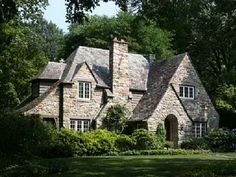 an old stone house surrounded by trees and bushes