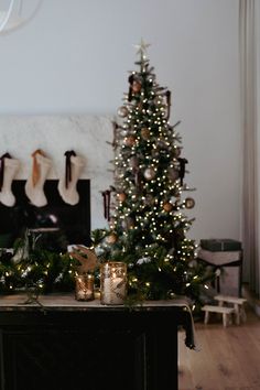 a decorated christmas tree in front of a fireplace