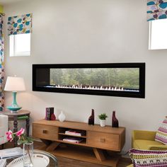 a living room filled with furniture and a flat screen tv mounted to the wall over a fireplace