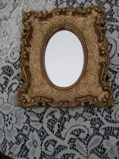 a small mirror sitting on top of a lace covered table cloth