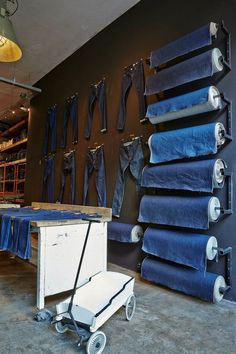 a room filled with lots of blue jeans hanging on the wall