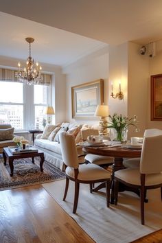 a living room filled with furniture and a chandelier hanging from the ceiling next to a window