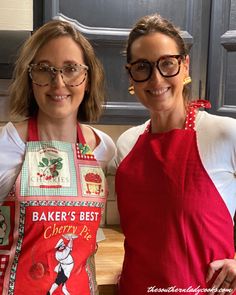 two women in red aprons standing next to each other