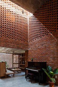 a living room filled with furniture and a large brick wall next to a piano on top of a hard wood floor