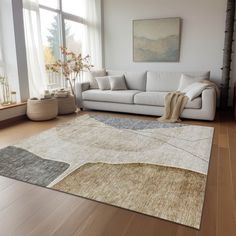 a living room with a white couch and large rug on top of the wooden floor