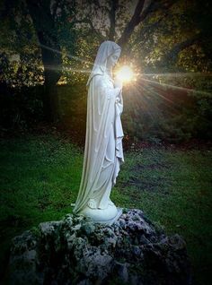 a white statue with the sun shining behind it