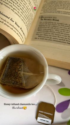 a cup of tea next to an open book