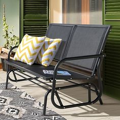 a black metal bench with yellow and white pillows