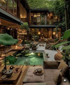 a living room filled with lots of furniture and plants next to a swimming pool in the middle