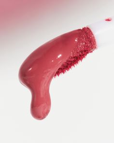 a close up of a lip brush with pink liquid on it