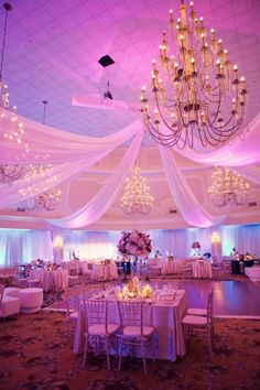 an elegant ballroom with chandeliers and tables