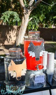 there are many cups and jars on the table with some animals painted on each one