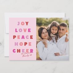 a pink card with the words joy love peace hope cheer and an image of two people