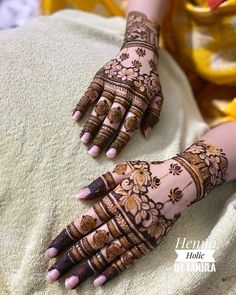 two hands with henna tattoos on them