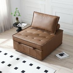 a brown leather couch sitting on top of a wooden floor next to a white rug