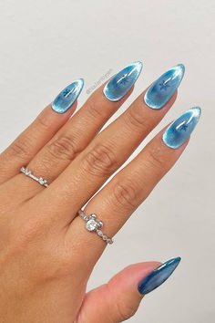 Mesmerizing Sky-Blue Cat Eye Nails with Frosty Aura and Snowflake Charm ✨❄️ // Photo Credit: Instagram @nailartbyjen Cat Eye Aura Nails, Aura Cat Eye Nails, Baby Blue Cat Eye Nails, Cat Eye Effect Nails Blue, Firework Cat Eye Nails, Blue Cat Eye Nails Coffin, Blue Cat Eye Nails With Snowflakes, Blue Grey Cat Eye Nails