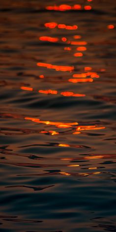 the sun is setting over the water and reflecting light on it's reflection in the water