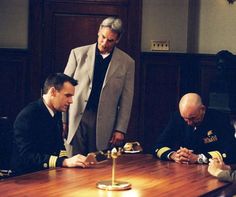 three men in uniform sitting at a table