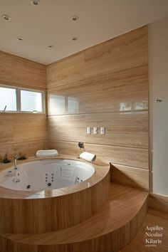 a large jacuzzi tub sitting in the middle of a wooden floored bathroom