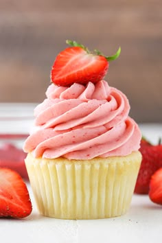 a cupcake with pink frosting and strawberries