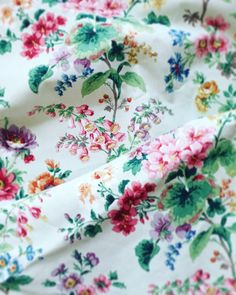 an image of a flowered fabric with many colors and flowers on it's surface