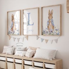 three framed pictures hang on the wall above a bench with storage bins underneath it