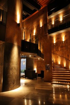 the lobby is lit up at night with warm lighting on the walls and flooring