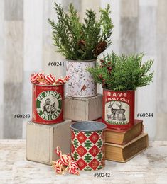 four tins with christmas decorations on them are sitting on a table next to each other