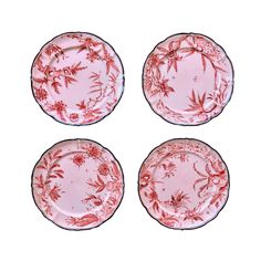 four pink plates with red designs on them