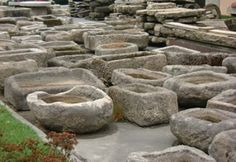 large stone bowls are lined up on the ground