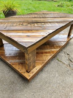 a wooden table sitting on top of a cement ground