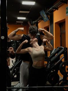 a man and woman standing next to each other in front of a gym equipment machine