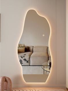 an illuminated mirror in the middle of a living room with furniture and pillows on it