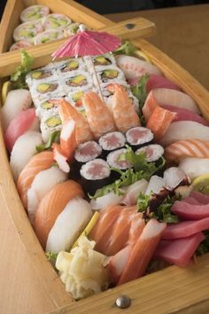 a wooden boat filled with lots of different types of sushi