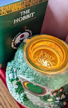 a glass jar sitting on top of a wooden table next to a green and yellow book