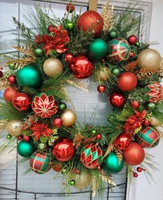 a wreath with christmas ornaments hanging on the front door