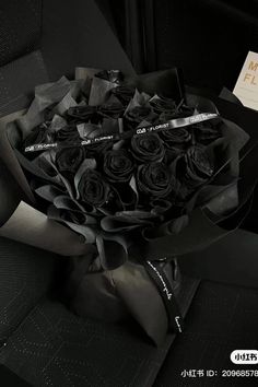 a bouquet of black roses sitting on the back seat of a car with a sign in front of it