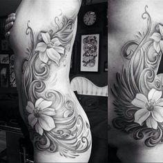 this is a black and white photo of a woman's back with flowers on it