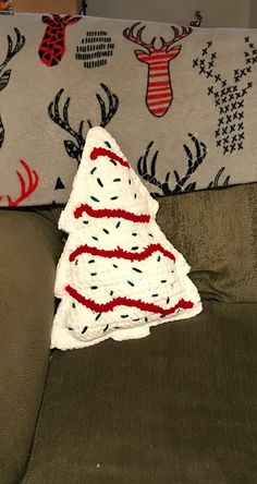 a crocheted christmas tree sitting on top of a couch next to a pillow