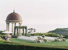 an outdoor ceremony setup with chairs and umbrellas