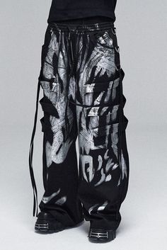 The Multi-Layered Striped Graffiti Cargo Pants are an exceptional piece, embodying a wild and expansive style. These wide-leg pants are adorned with a graffiti-style paintbrush effect throughout, creating a vibrant and artistic appearance. The intricate design is further enhanced by meticulous spliced and strap detailing, adding depth and a tactile dimension to the garment. An elastic waistband ensures a comfortable and adjustable fit, making these pants suitable for a variety of body types. The Luxury Faded Bottoms For Streetwear, Skelatin Pants, Cheap Trendy Acid Wash Bottoms, Luxury Trendy Bottoms For Streetwear, Cheap Ripped Bottoms For Streetwear, Luxury Trendy Pants For Streetwear, Cheap Rave Style Party Bottoms, Luxury Distressed Pants For Streetwear, Customized Mens Pants