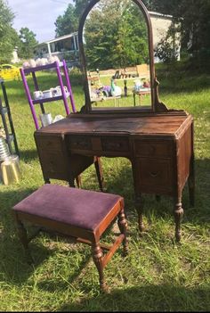 an old vanity and stool are sitting in the grass