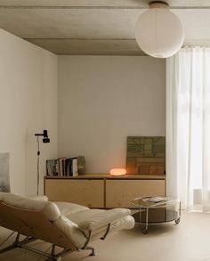 a living room filled with furniture next to a window covered in white drapes and curtains