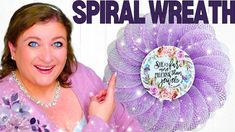 a woman holding up a purple wreath with the words spiral wreath on it