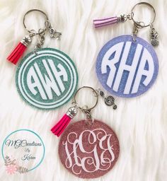 two monogrammed keychains with tassels on white furnishing