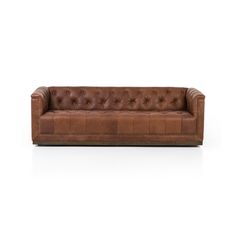 a brown leather couch sitting on top of a white floor