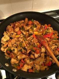 a pan filled with chicken and vegetables on top of a stove