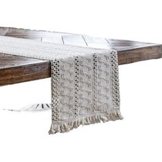 a wooden bench with a white blanket hanging from it's back end, on top of wood planks