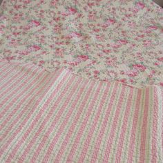 a pink and white bedspread with flowers on it